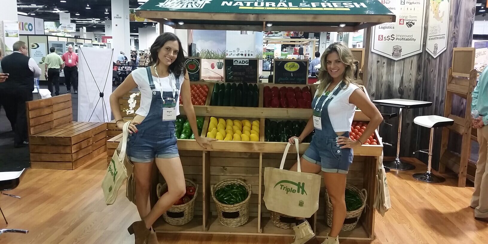 Models working a food market-themed booth.
