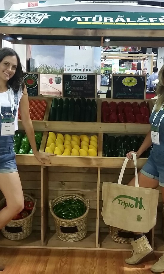Models working a food market-themed booth.