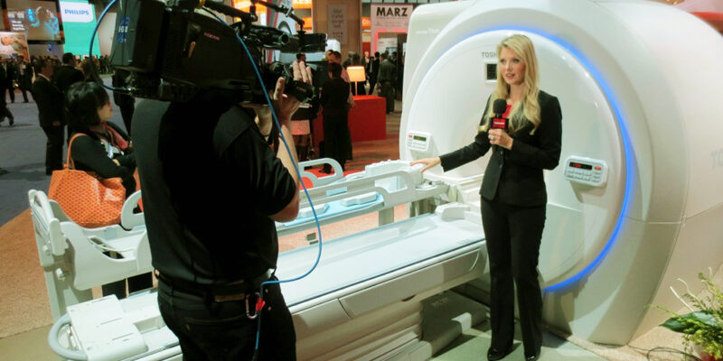Trade show model and presenter explaining technical equipment