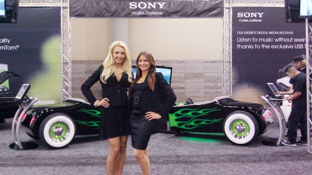two models in front of a car separated in half at Sony and Best Buy exhibit booth